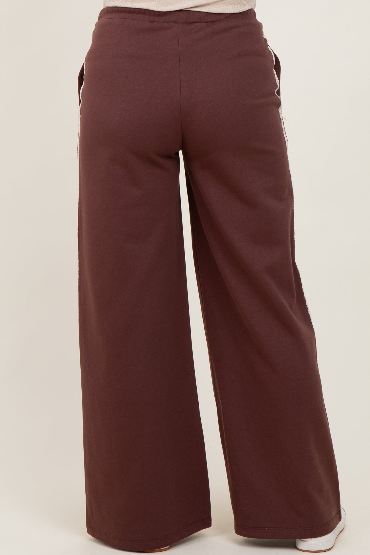 maternity wear in a burgundy wide-leg sweatpants style, shown from the back