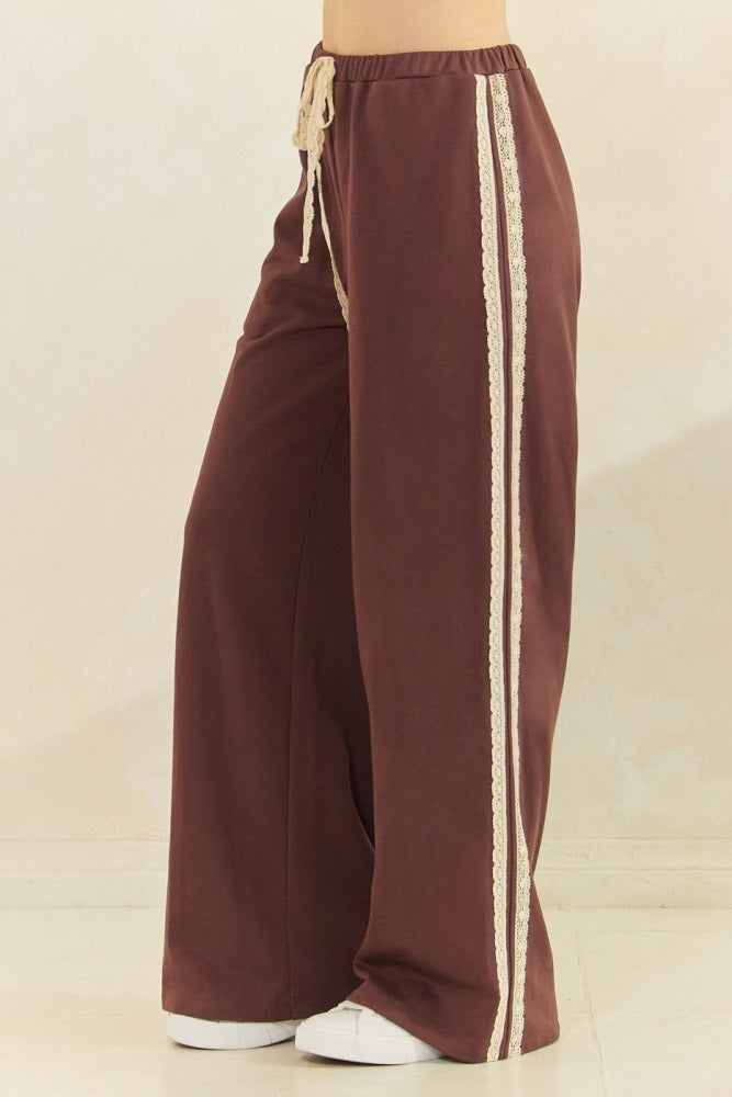 woman wearing brown wide-leg pants with lace side details and a drawstring waist