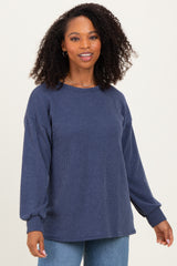 woman wearing a navy blue ribbed long sleeve sweater with a relaxed fit and balloon sleeves