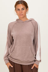 woman wearing a brown ribbed hoodie with a front pocket and white side stripes