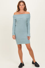 woman wearing a light blue off-the-shoulder ribbed sweater dress with long sleeves and a fitted silhouette
