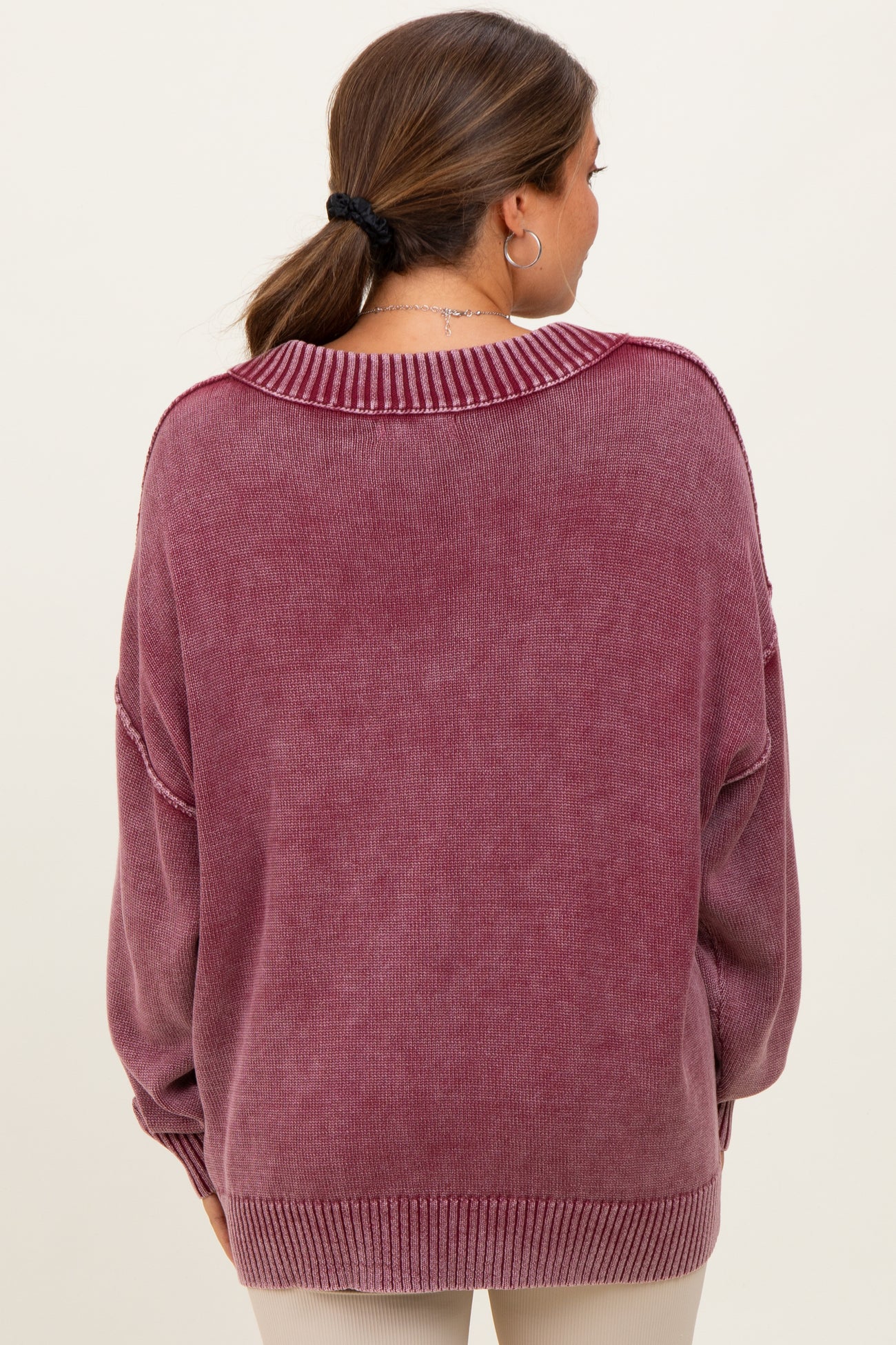 woman wearing a oversized purple maternity sweater, showing the back view with drop shoulders and a relaxed fit