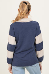 woman wearing a striped navy and cream maternity sweater with long sleeves and a relaxed fit, showing the back view.