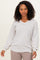woman wearing a cream and gray striped oversized sweater with a v-neck and balloon sleeves