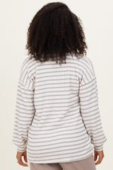 woman wearing a light grey and white striped oversized sweater with long sleeves, viewed from the back
