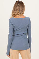 woman wearing a back view of a blue ribbed maternity top with long sleeves