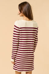 woman wearing a maroon and cream striped knit sweater dress with button details on the shoulders from the back