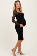 woman wearing a black maternity dress with lace long sleeves and a visible baby bump