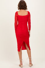woman wearing a red long sleeve bodycon dress with lace sleeves and ruching detail, showing a back slit