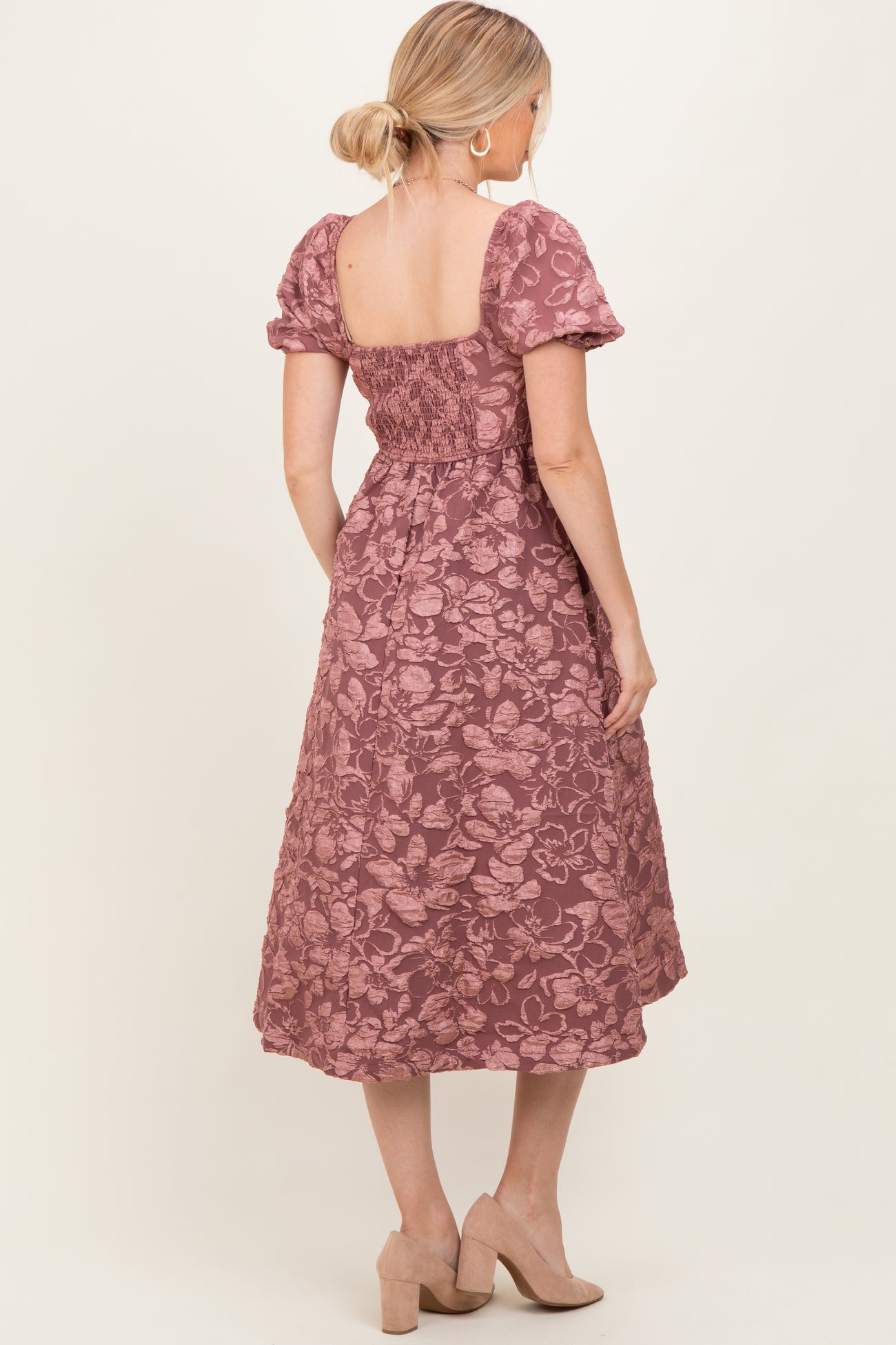 woman wearing a mauve floral midi dress with short puff sleeves and a smocked back detail