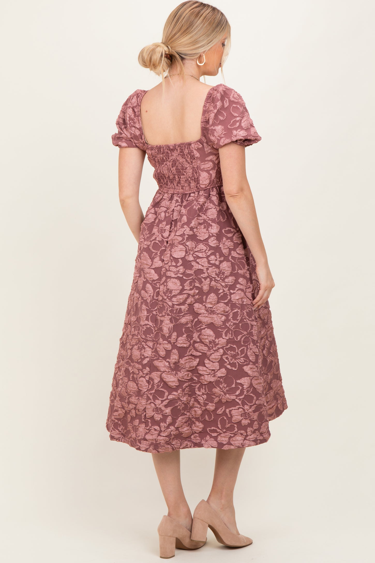 woman wearing a mauve floral midi dress with short puff sleeves and a smocked back detail