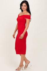 woman wearing a fitted red off-the-shoulder midi dress and white high-heeled sandals
