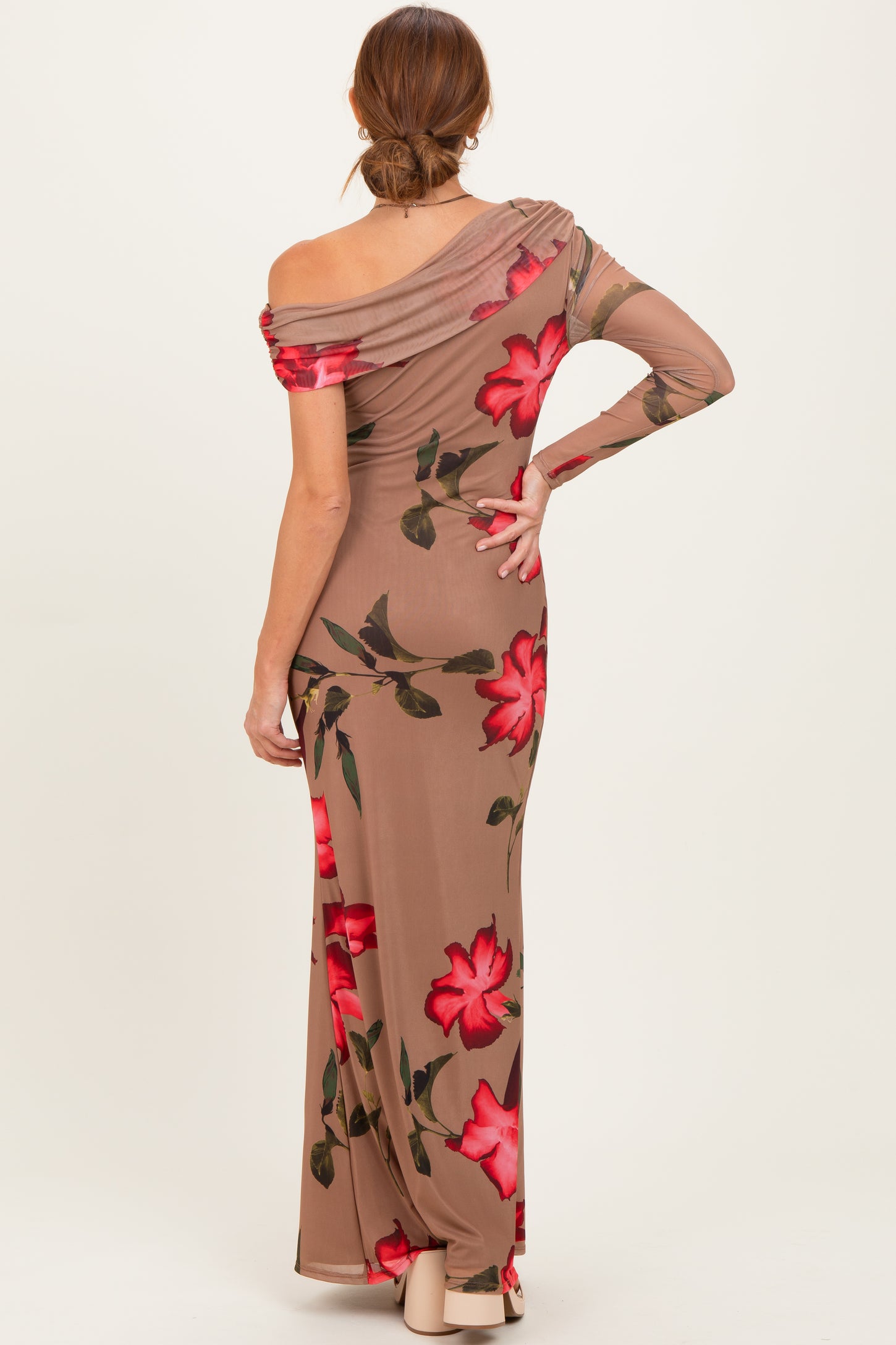 woman wearing a brown off-shoulder maxi dress with red floral patterns and a fitted silhouette, viewed from the back