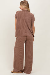 woman wearing a brown striped short sleeve top and wide-leg pants, viewed from the back