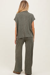 woman wearing a ribbed olive green maternity lounge set, featuring a short sleeve top and wide-leg pants from the back