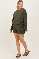 woman wearing a dark olive green sweatshirt and matching shorts with a casual fit and comfortable sandals
