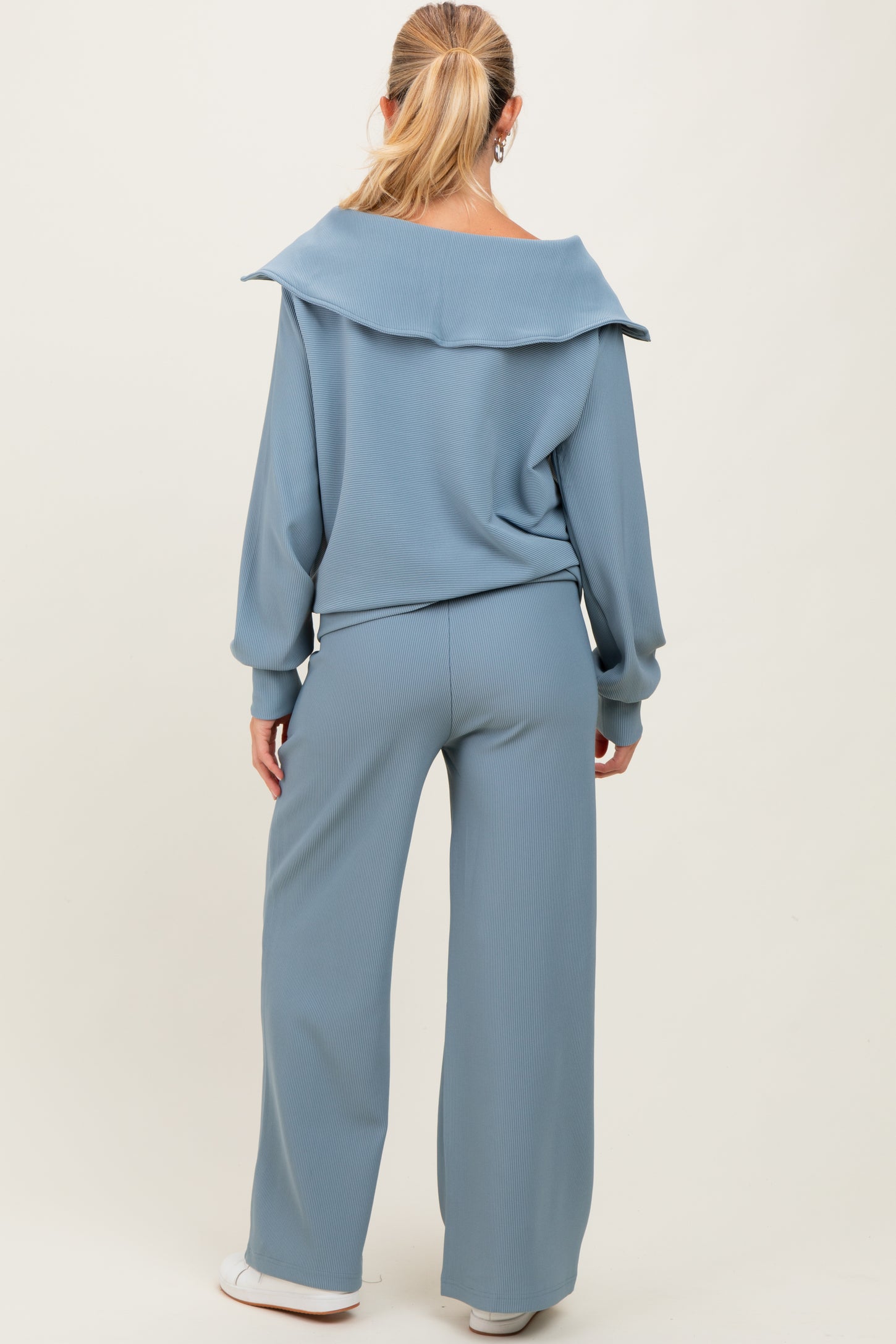 woman wearing a light blue maternity lounge set with a relaxed fit top and wide-leg pants, showing her back