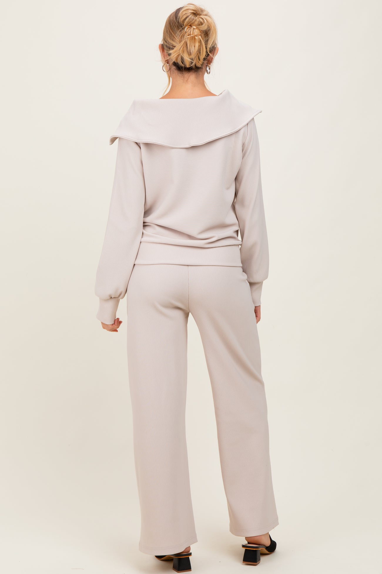 woman wearing a light mauve ribbed maternity lounge set with an oversized collar and wide-leg pants