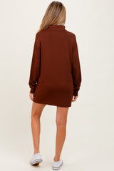 woman wearing a brown maternity oversized sweater dress, seen from the back, casual style with long sleeves