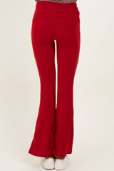 woman wearing red flared pants, viewed from the back, with a high waistband and a fitted style