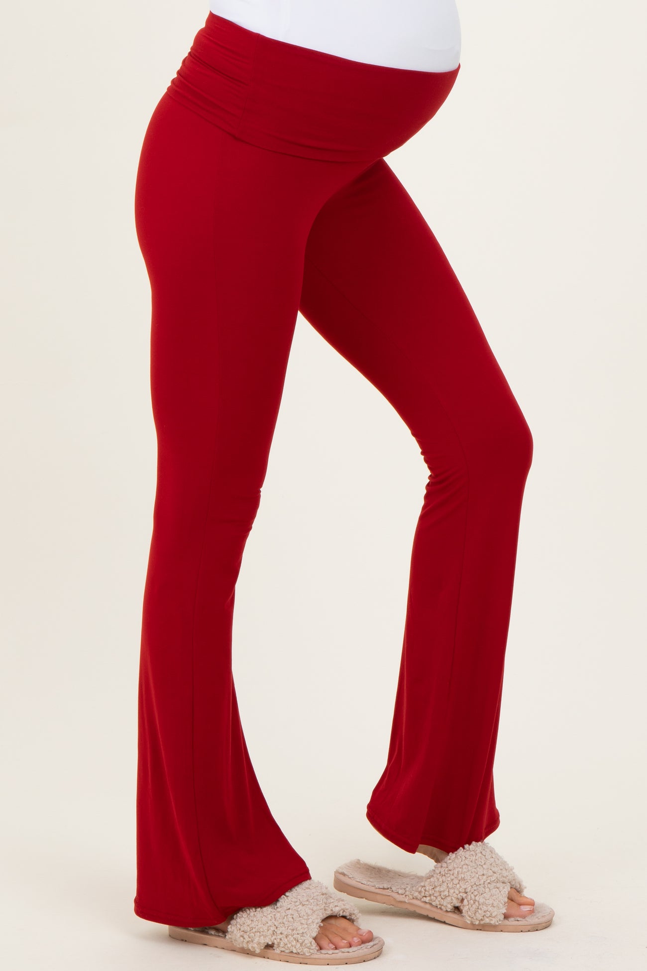 woman wearing a red maternity flared leggings with a foldable waistband and a visible baby bump