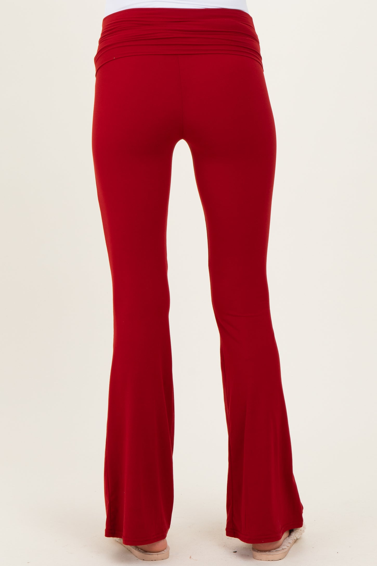 maternity wear in red flared pants with a soft, stretchy waistband, viewed from the back