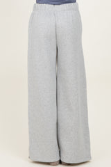 woman wearing light grey wide-leg sweatpants with an elastic waistband, seen from the back
