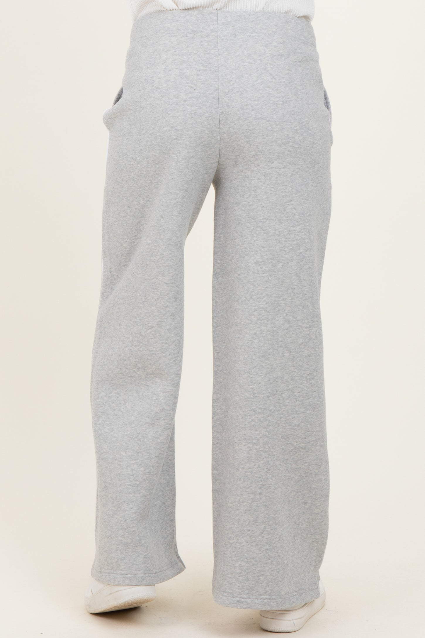 woman wearing gray maternity sweatpants with a wide leg and side pockets, showing the back view