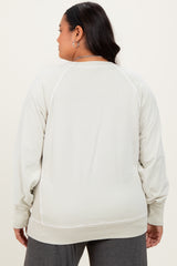 woman wearing a light gray plus size sweatshirt with a relaxed fit and ribbed cuffs, viewed from the back