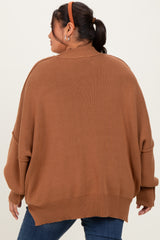 woman wearing a brown oversized sweater with a ribbed texture and dropped shoulder seams, viewed from the back