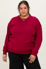 woman wearing a burgundy oversized sweatshirt with drop shoulder seams and relaxed fit