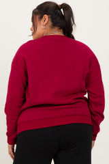 woman wearing a burgundy oversized sweatshirt with long sleeves and a crew neckline, view from the back
