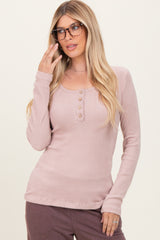 woman wearing a light mauve long sleeve henley top with button details and styled with glasses