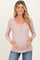 woman wearing a dusty rose ribbed maternity top with button details and a visible baby bump