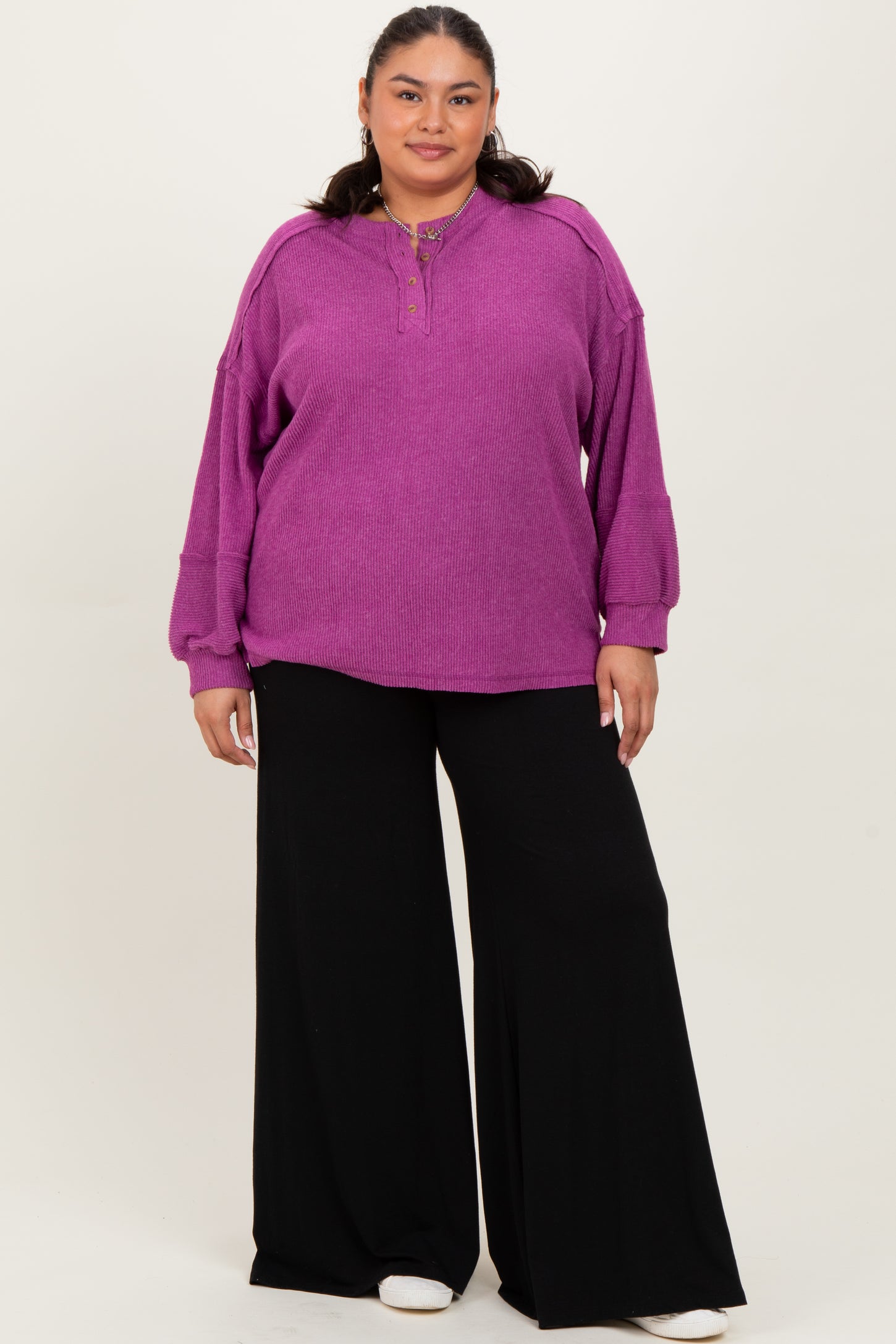woman wearing a purple oversized sweater with buttons and black wide-leg pants