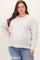woman wearing a light beige ribbed maternity plus sweater with a relaxed fit and a visible baby bump