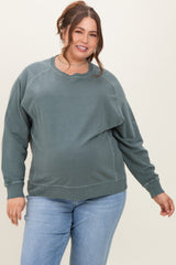 woman wearing a green oversized maternity sweatshirt with a relaxed fit and a visible baby bump