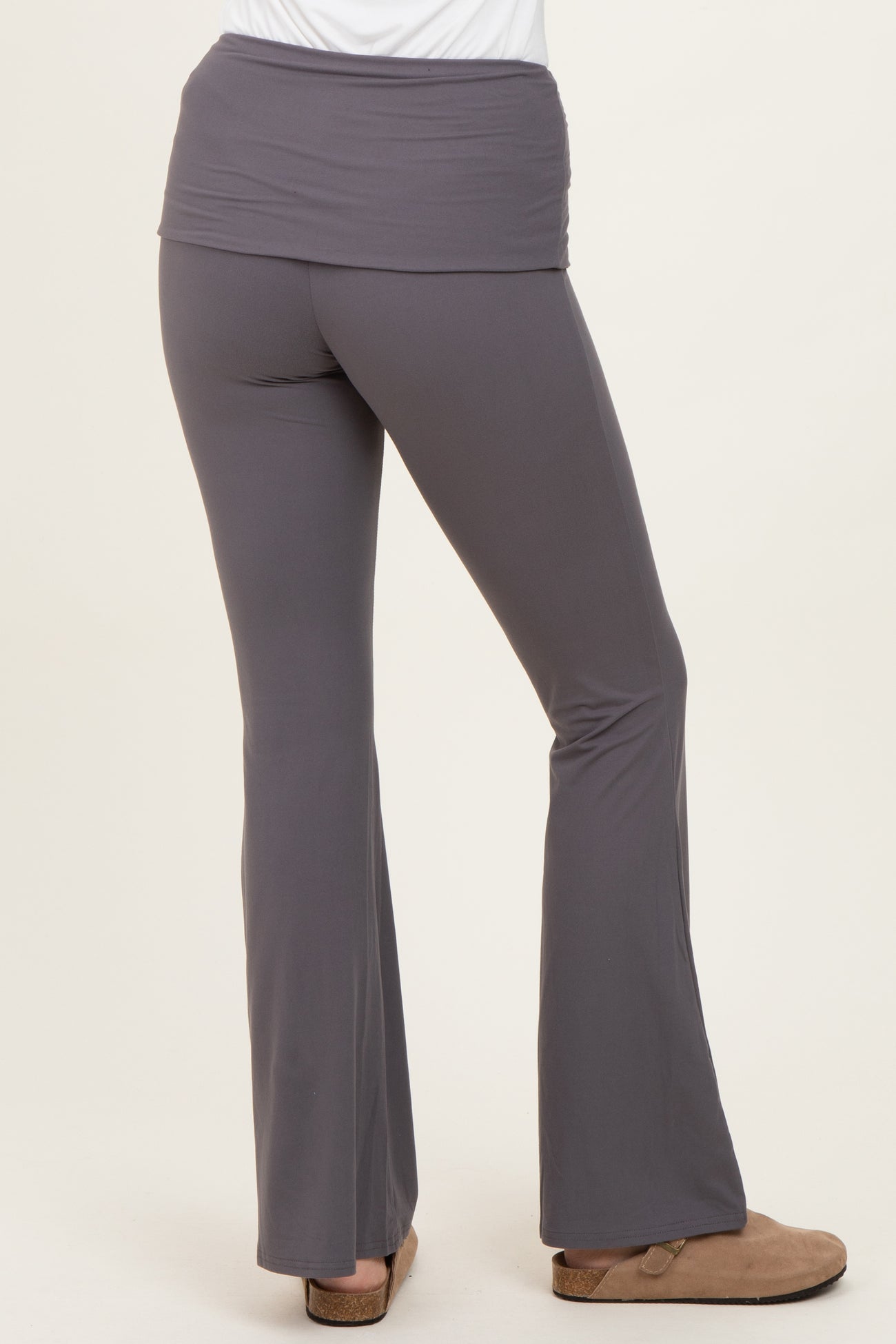 woman wearing gray flared yoga pants with a wide waistband, viewed from the back