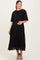 woman wearing a black pleated maternity dress with a cape detail and holding her baby bump