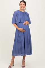woman wearing a pleated blue maternity dress with flutter sleeves and holding her baby bump
