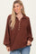 woman wearing a rust brown button-up collared oversized ribbed sweater with long sleeves and a relaxed fit