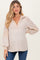 woman wearing a beige maternity top with a v-neck and puffed sleeves, showcasing her baby bump