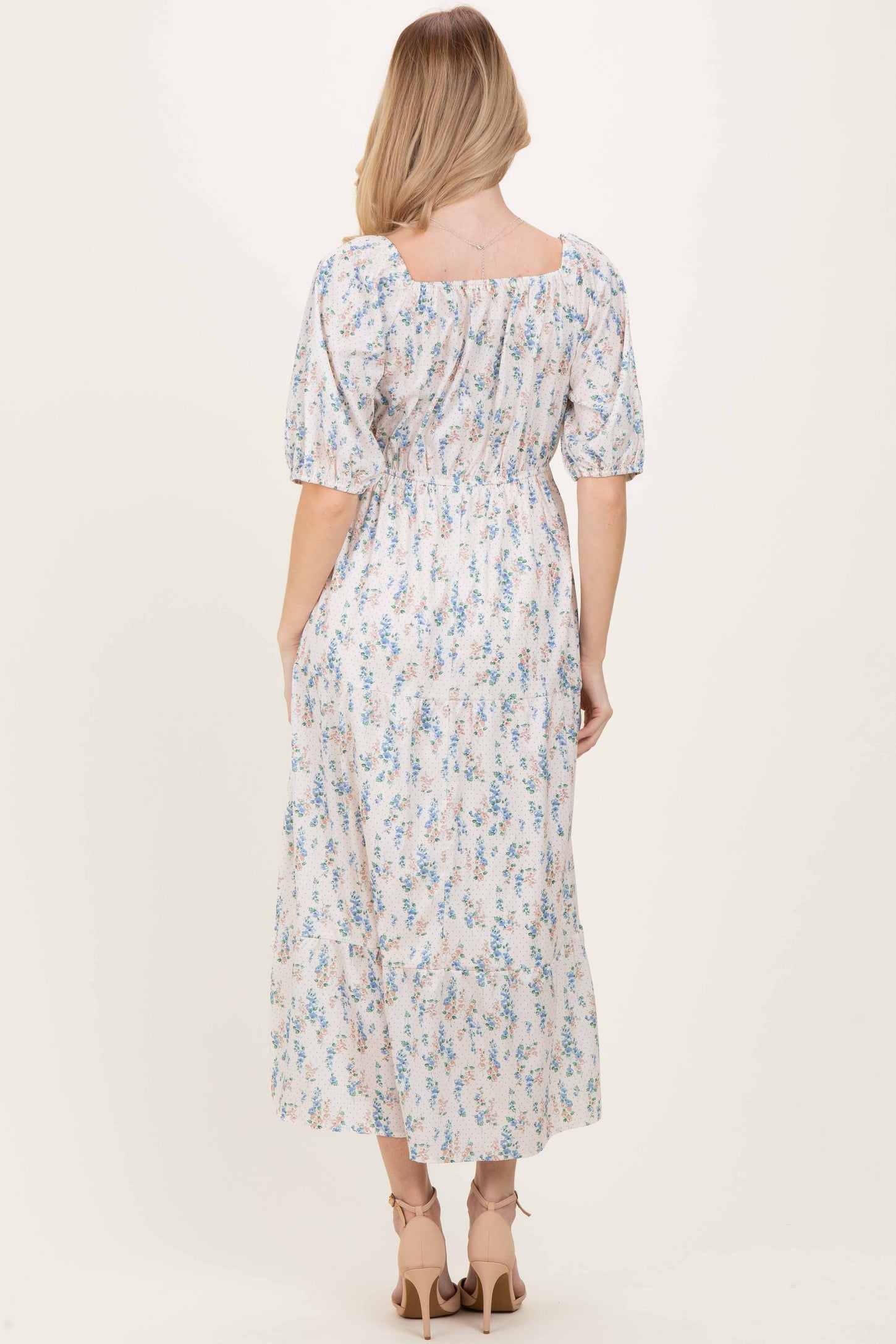woman wearing a floral print midi dress with puff sleeves and a square neckline, shown from the back