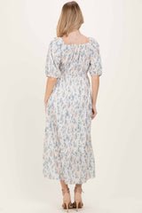 woman wearing a floral print midi dress with puff sleeves and a square neckline, shown from the back