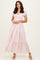 woman wearing a light pink tiered maxi dress with short puff sleeves and a smocked bodice