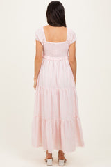 woman wearing a pink striped maxi dress with smocked bodice and tiered skirt, viewed from the back