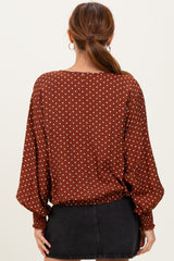 woman wearing a brown polka dot blouse with a relaxed fit and balloon sleeves, viewed from the back