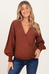 woman wearing a brown polka dot wrap maternity top with balloon sleeves and a v-neckline