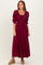 woman wearing a burgundy puff sleeve maxi dress with a smocked bodice and drawstring detail