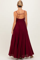 woman wearing a burgundy sleeveless maxi maternity dress with a smocked bodice and back detail